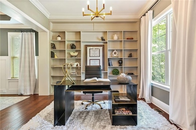Office featuring a chandelier, crown molding, and dark wood finished floors
