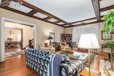 Living room featuring coffered ceiling, a notable 