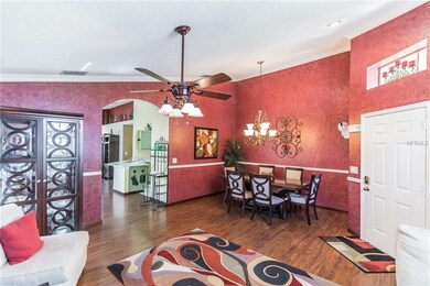 Enter front door to the formal living and dining room with laminate floors, crown molding and ceiling fan.