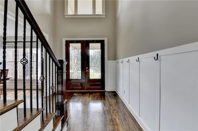 Foyer with stairs, dark wood-style flooring, and a high ceiling