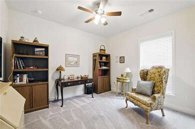 Living area featuring a ceiling fan, light carpet,