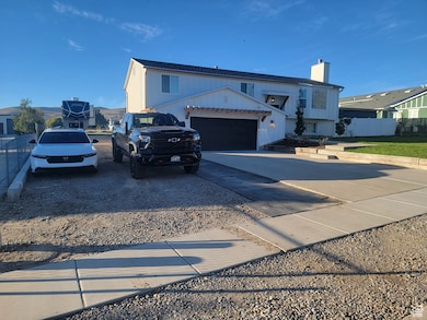 View of front of property featuring driveway, a chimney, and a garage