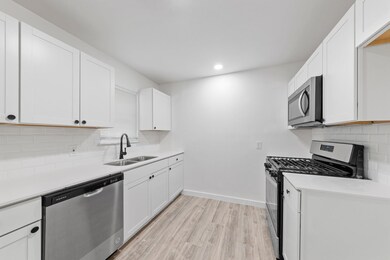 Kitchen with decorative backsplash, light hardwood
