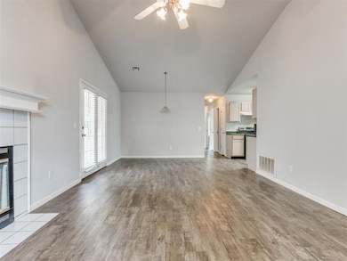 living room featuring high vaulted ceiling, ceiling fan, wood finished floors, and fireplace