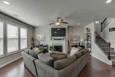 Living room with stairway, a glass covered firepla