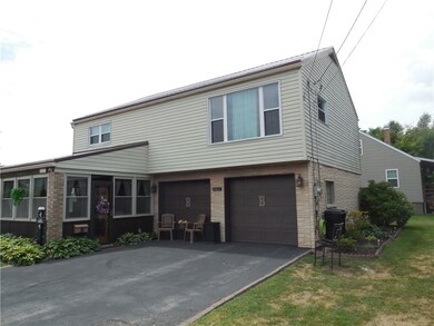 Blacktop driveway with two stall garages.