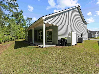 Rear view of property featuring a patio, a lawn, a
