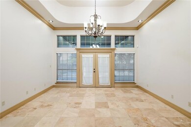 Tiled spare room with a chandelier, a tray ceiling, french doors, and crown molding