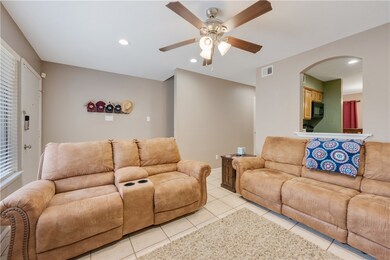 Living room featuring a ceiling fan, light tile pa