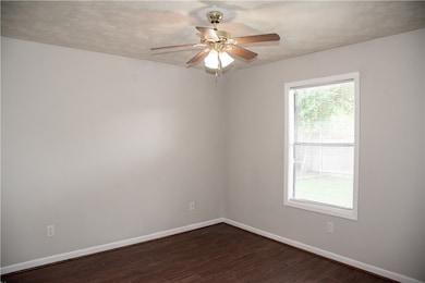 Spare room featuring dark wood-style floors, a cei
