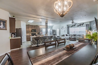 Dining room featuring a chandelier, a ceiling fan, and light tile patterned floors