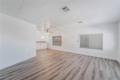 Unfurnished living room with baseboards, visible vents, and light wood-style floors