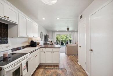 Kitchen with white cabinets, sink, dark wood-type 