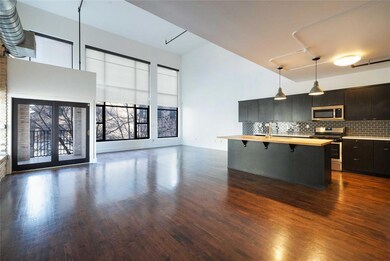 Kitchen featuring a kitchen bar, hanging light fi