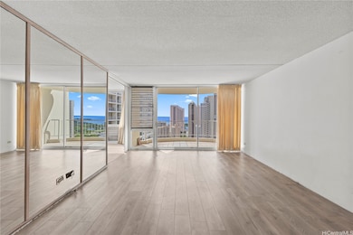 A bright, open living area with floor-to-ceiling windows frames wide ocean and city views.