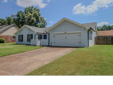 Ranch-style house with a garage and a front lawn