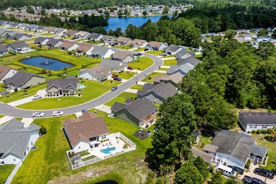 Aerial view of property and surrounding area featuring nearby suburban area