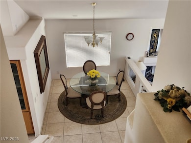 Dining space with a chandelier and light tile patt