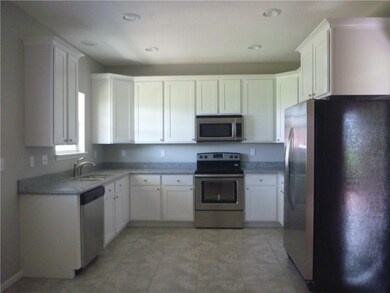 Kitchen featuring granite counter tops,stove , dis