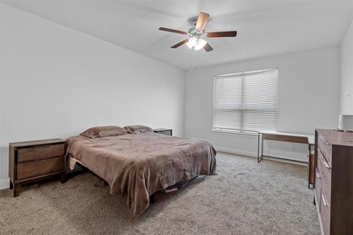 Carpeted bedroom with ceiling fan