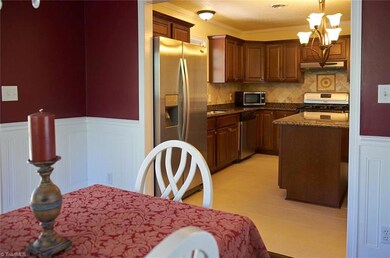 Dining room with beautiful wainscotting opens to kitchen.