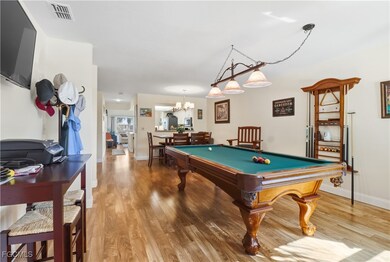 Playroom featuring light wood-type flooring, pool table, and a chandelier