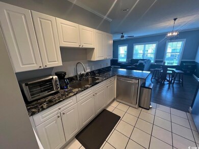 Kitchen featuring stainless steel dishwasher, white cabinetry, a peninsula, a ceiling fan, and healthy amount of natural light