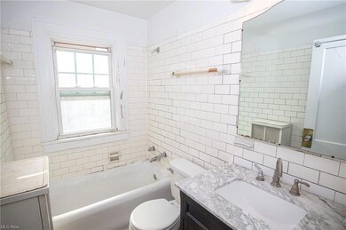 Full bathroom featuring large vanity, tasteful bac