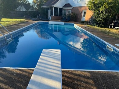 View of pool featuring a sunroom, a diving board, 