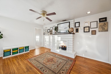 Unfurnished living room featuring a multi sided fireplace, wood finished floors, ceiling fan, and recessed lighting