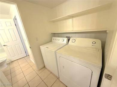 Laundry room with washer and clothes dryer and lig