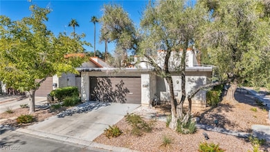 View of front of property with driveway, stucco siding, and a garage