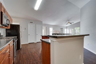 Kitchen featuring electric range, dark countertop