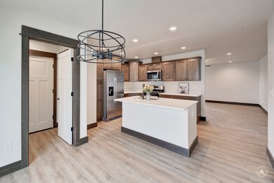 Kitchen featuring a center island, a chandelier, light countertops, stainless steel appliances, and recessed lighting