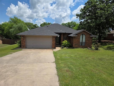 View of front facade featuring driveway, brick sid