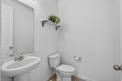 Half bath featuring baseboards and wood finished floors