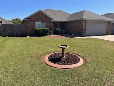 View of front of home with brick siding, a garage, roof with shingles, and concrete driveway