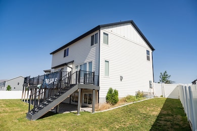 Rear view of house featuring a fenced backyard, stairway, a patio area, a wooden deck, and board and batten siding