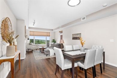 Dining space featuring dark wood-style flooring and baseboards
