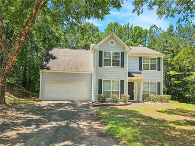 View of front of home featuring driveway, a garage, a chimney, and a front lawn