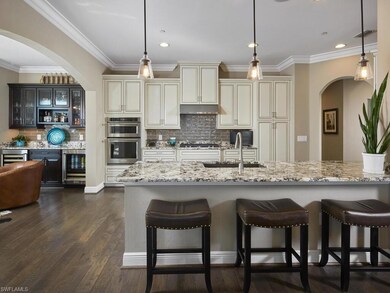 Kitchen with sink, light stone counters, and cream