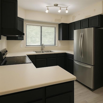 Kitchen with exhaust hood, electric range oven, a 
