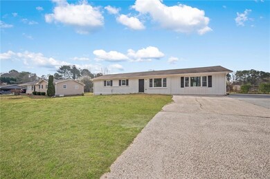 Ranch-style house featuring driveway and a front y