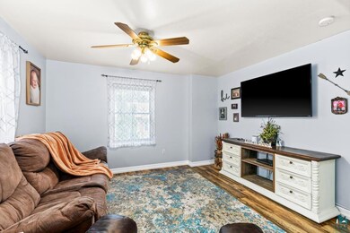 Living area featuring a ceiling fan, wood finished