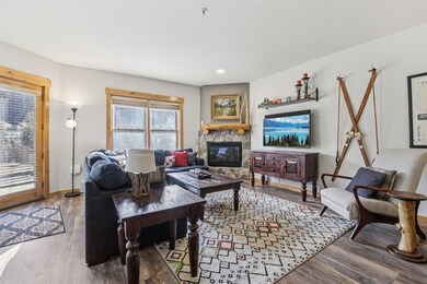 Living room featuring a stone fireplace, wood finished floors, and recessed lighting