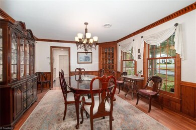 Beautiful Hardwood floor set off the Dining Room - Area rugs remains with property.  Note the custom crown molding - Orginal owner was involved with the furniture business of High Point.