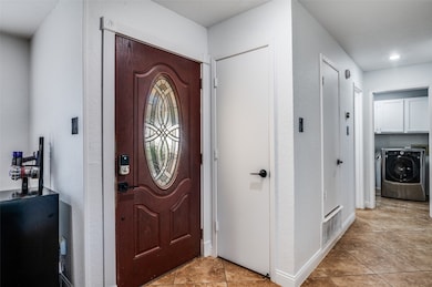 Foyer featuring light tile patterned floors and a textured wall
