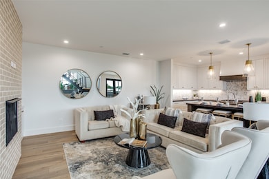 Living room featuring a fireplace, light wood-style floors, and recessed lighting