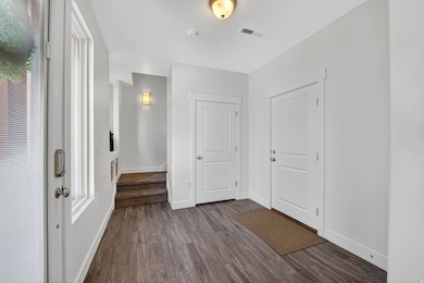 Entryway featuring dark wood finished floors and stairs