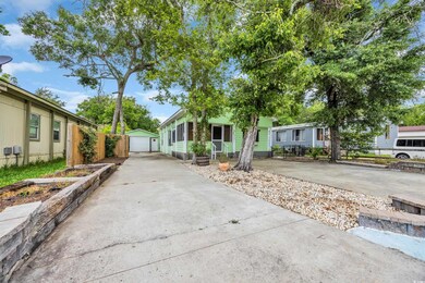 View of front of property with concrete driveway, an outbuilding, and a detached garage